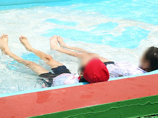 水で冷えた身体を幼児用プールで温める2人