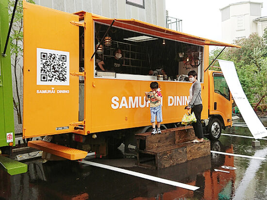 雨も気にせず餃子を受け取る息子