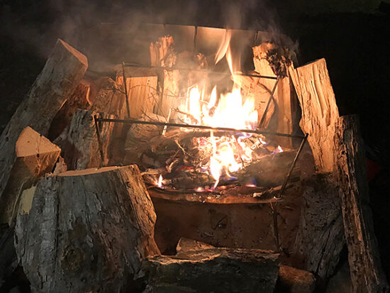 焚き火の周りに薪を置いて乾かします。